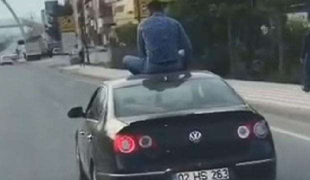 Otomobilin üstüne oturarak yolculuk yaptı