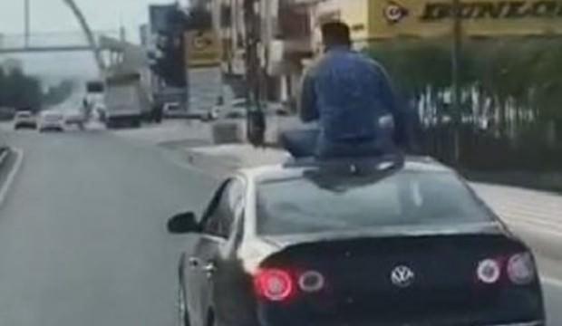 Otomobilin üstüne oturarak yolculuk yaptı